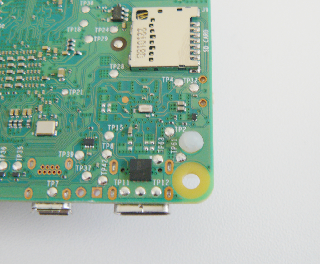 The underside of the Raspberry Pi 5 circuit board showing the plastic lugs from the active cooler coming through the board.