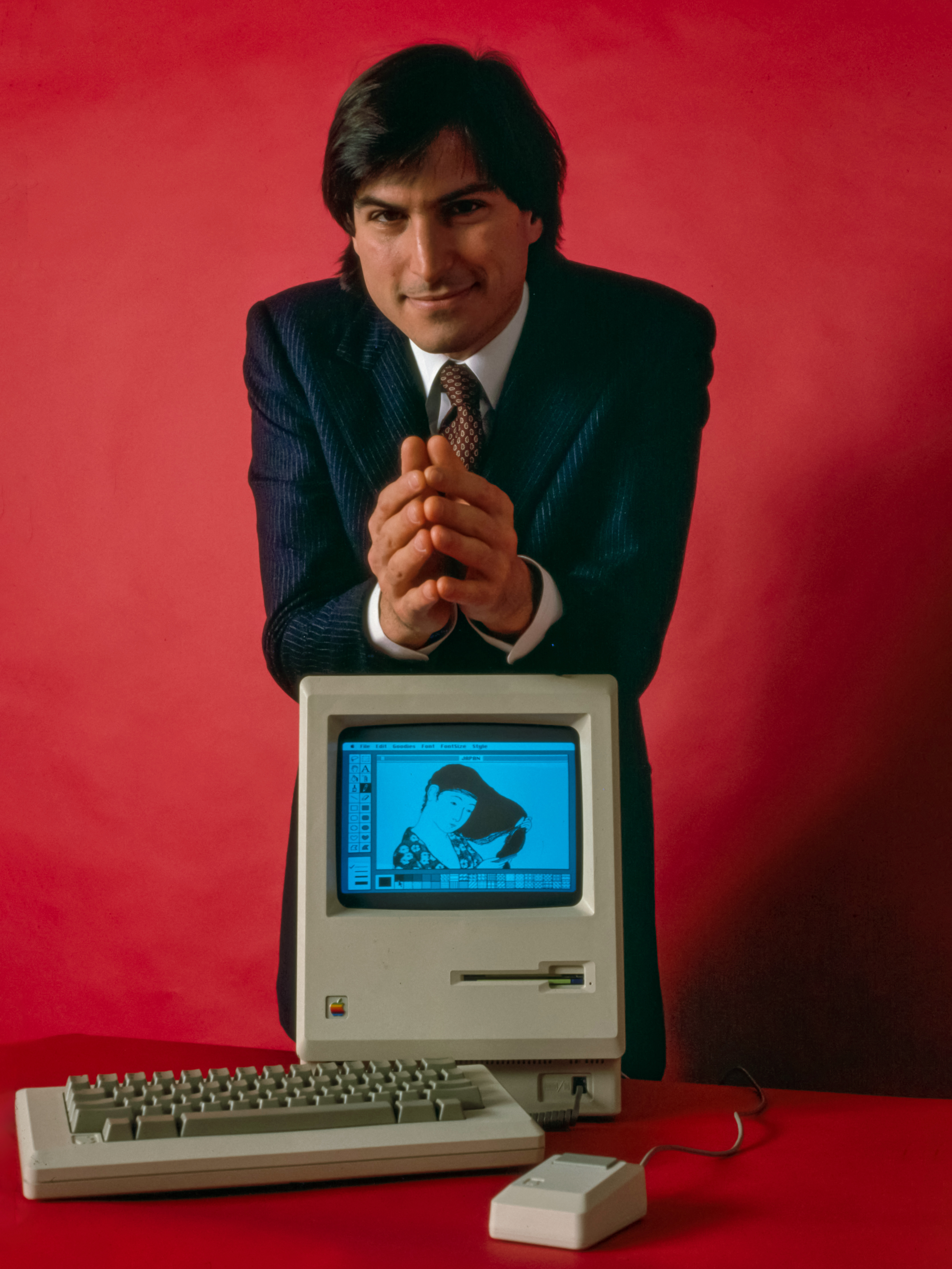 Steve Jobs depicted with the original Macintosh computer.